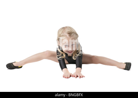 little girl in bodysuit for rhythmic gymnastics trying to do the splits isolated on white Stock Photo