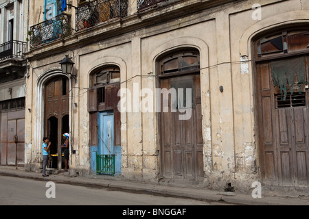 People talk in a doorway, Habana Vieja, Havana, Cuba Stock Photo