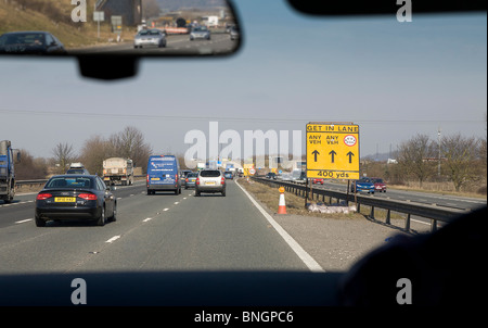 Traffic on motorway with road works sign, England UK Stock Photo