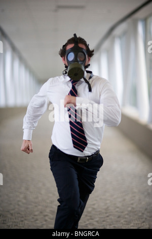 Running businessman wearing gas mask Stock Photo