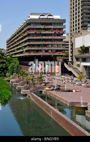 Lake & water feature fountains at urban Barbican Centre brutalist architecture high rise landmark skyscraper apartment homes City of London England UK Stock Photo