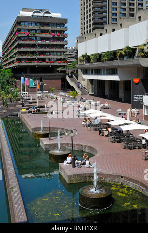 Lake & water feature fountains at urban Barbican Centre brutalist architecture high rise landmark skyscraper apartment homes City of London England UK Stock Photo