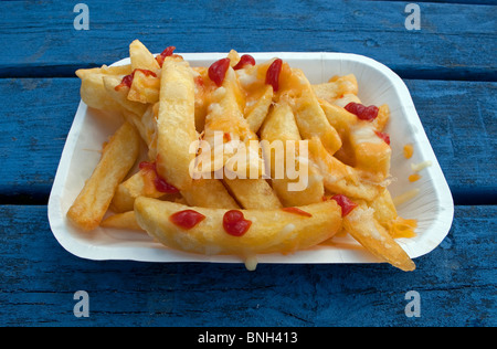 a tray of fried chips with tomato ketchup on them Stock Photo