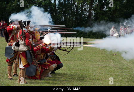 8th Kings Regiment foot soldiers firing flintlock muskets on the battlefield. Re-enactment Stock Photo