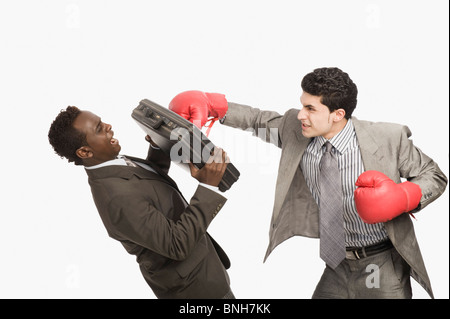 Businessman defending himself from the punch of his colleague Stock Photo