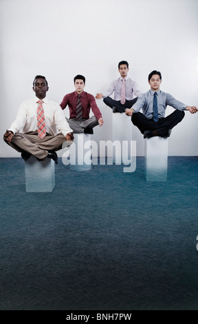 Four businessmen practicing yoga Stock Photo