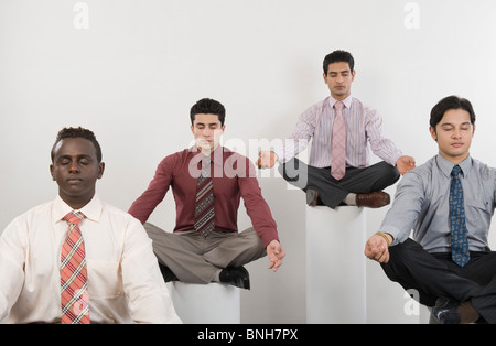 Four businessmen practicing yoga Stock Photo