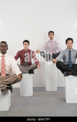 Four businessmen practicing yoga Stock Photo