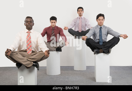 Four businessmen practicing yoga Stock Photo