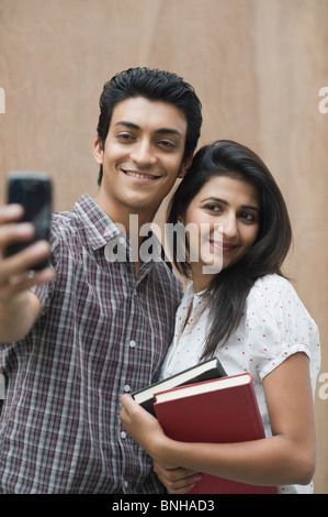 College students taking a picture of themselves with a camera mobile Stock Photo