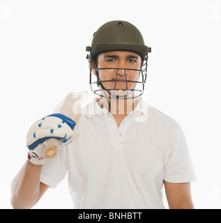 Portrait of a cricket batsman holding a bat and smiling Stock Photo