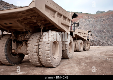 Haul trucks in mine, dump trucks or earth movers parked together in quarry Stock Photo