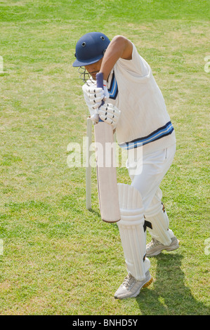 Cricket batsman playing a defensive stroke Stock Photo
