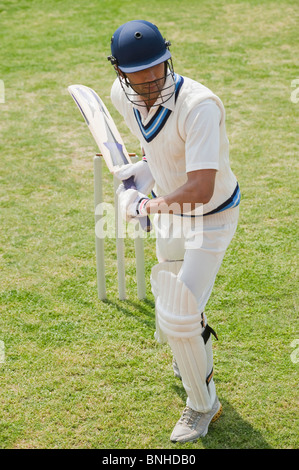 Cricket batsman playing a defensive stroke Stock Photo