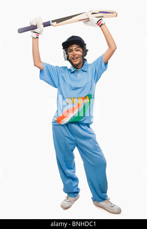 Female cricketer raising bat in celebration Stock Photo