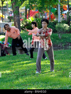 Woman performing Tai Chi exercises with a large sword in Lumpini Park, Bangkok Stock Photo