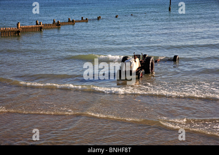 Tractor and boat trailer in the sea at Overstrand, Norfolk, England, United Kingdom, after launch of inshore fishing boat. Stock Photo