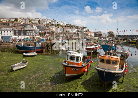 Mevagissey harbour, the tide is out leaving the boats beached in dry dock Stock Photo