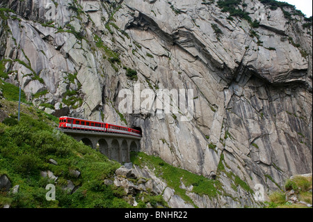 Switzerland. Travel by Train in Switzerland. The Matterhorn-Gotthard bahn train crosses above the Devil's Bridge, the Teufelsbr Stock Photo