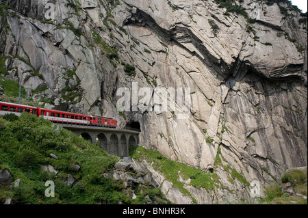 Switzerland. Travel by Train in Switzerland. The Matterhorn-Gotthard bahn train crosses above the Devil's Bridge, the Teufelsbr Stock Photo