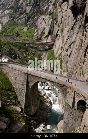 Switzerland. Travel by Train in Switzerland. The Matterhorn-Gotthard bahn train crosses above the Devil's Bridge, the Teufelsbru Stock Photo