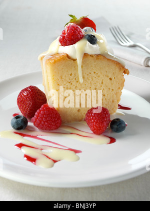 Spanish traditional sponge cake with evaporated and condensed milk topped with whipped cream and fruit Stock Photo