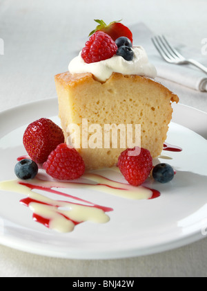 Spanish traditional sponge cake with evaporated and condensed milk topped with whipped cream and fruit Stock Photo