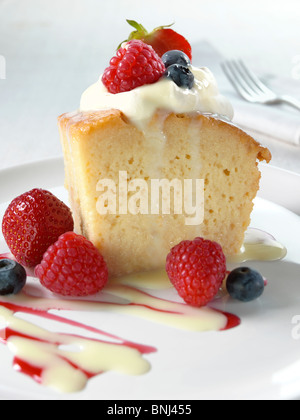 Spanish traditional sponge cake with evaporated and condensed milk topped with whipped cream and fruit Stock Photo