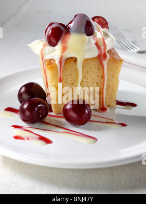 Spanish traditional sponge cake with evaporated and condensed milk topped with whipped cream and fruit Stock Photo