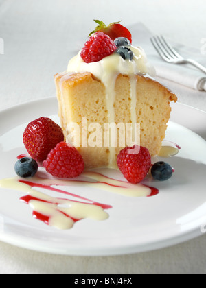 Spanish traditional sponge cake with evaporated and condensed milk topped with whipped cream and fruit Stock Photo