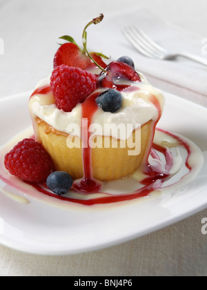 Spanish traditional sponge cake with evaporated and condensed milk topped with whipped cream and fruit Stock Photo