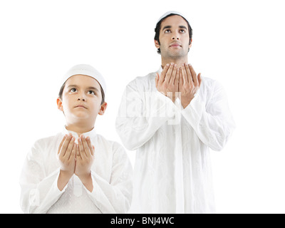 Muslim man and his son praying Stock Photo