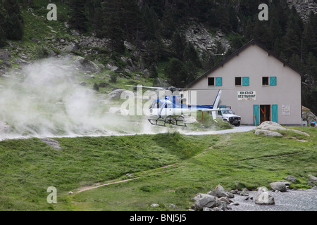 Helicopter Landing Next to a Restaurant at the Lac De Gaube in the French Pyrenees to Collect Supplies Stock Photo