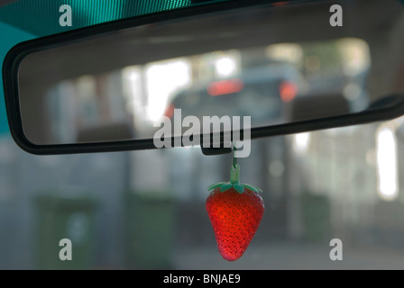 Car air freshener hanging from internal rear view drivers car mirror. London UK Stock Photo