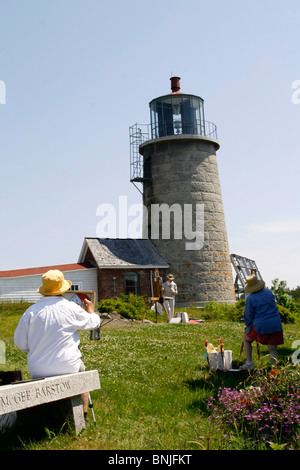 Maine coast Monhegan Island artist colony New England USA remote offshore art class painting woman at lighthouse Stock Photo