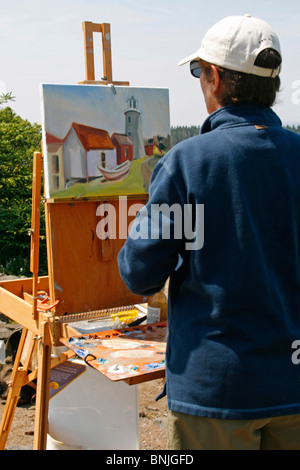 Maine coast Monhegan Island artist colony New England USA remote offshore art class painting woman at lighthouse Stock Photo