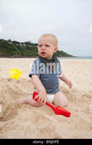 Baby boy 14 months old playing on the beach with a bucket and spade Carbis Bay beach, St Ives, Cornwall, England, United Kingdom. Stock Photo