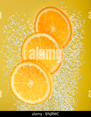 Fresh orange dropped into water with bubbles Stock Photo