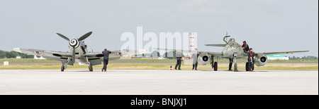 Panorama shot with Messerschmitt BF 109 (original) and ME 262 jet fighter (replica) standing nearby on the runway. Ground crew. Stock Photo