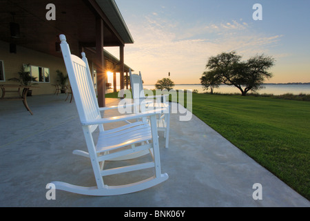 Rocking chairs on patio overlooking sunset over Bogue Sound, Country Club of Crystal Coast, Atlantic Beach, North Carolina, USA Stock Photo