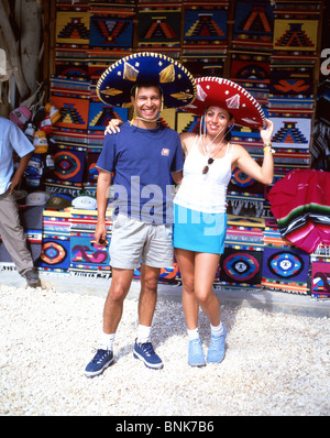 Couple with Mexican hats in roadside stall, Tulum, Quintana Roo, Mexico Stock Photo