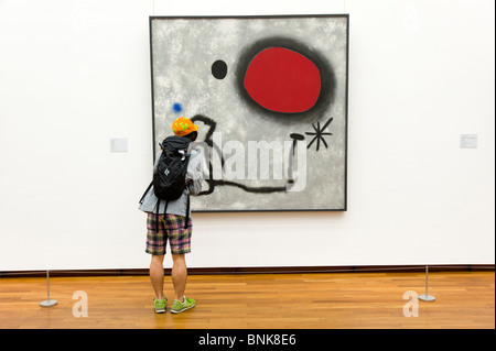 Young man looking at modern art oil painting by Joan Miro in the National Museum of Western Art, Tokyo, Japan Stock Photo