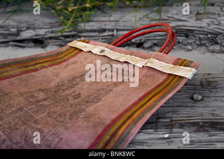 A worn, old bag lying on a piece of wood. Stock Photo