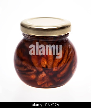 Pecan nuts in acacia honey in glass jar Stock Photo