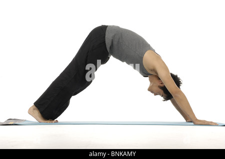 Young man doing yoga, downward dog position Stock Photo