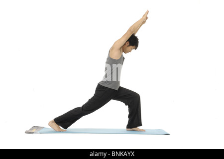 young man doing standing yoga pose indoors Stock Photo