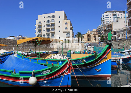 Luzzu traditional fishing boats beside the Gillieru Harbour Hotel, Buġibba, St Paul's Bay, north Malta, Mediterranean, Europe Stock Photo