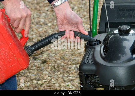 Filling petrol tank on petrol driven rotary mower Stock Photo