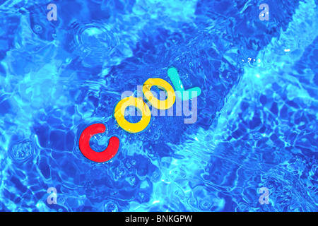 The word SWIMMING made from foam letters floating on the water surface ...