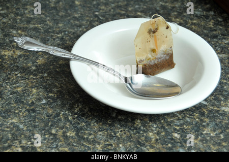 Teabag in a small white ceramic dish Stock Photo